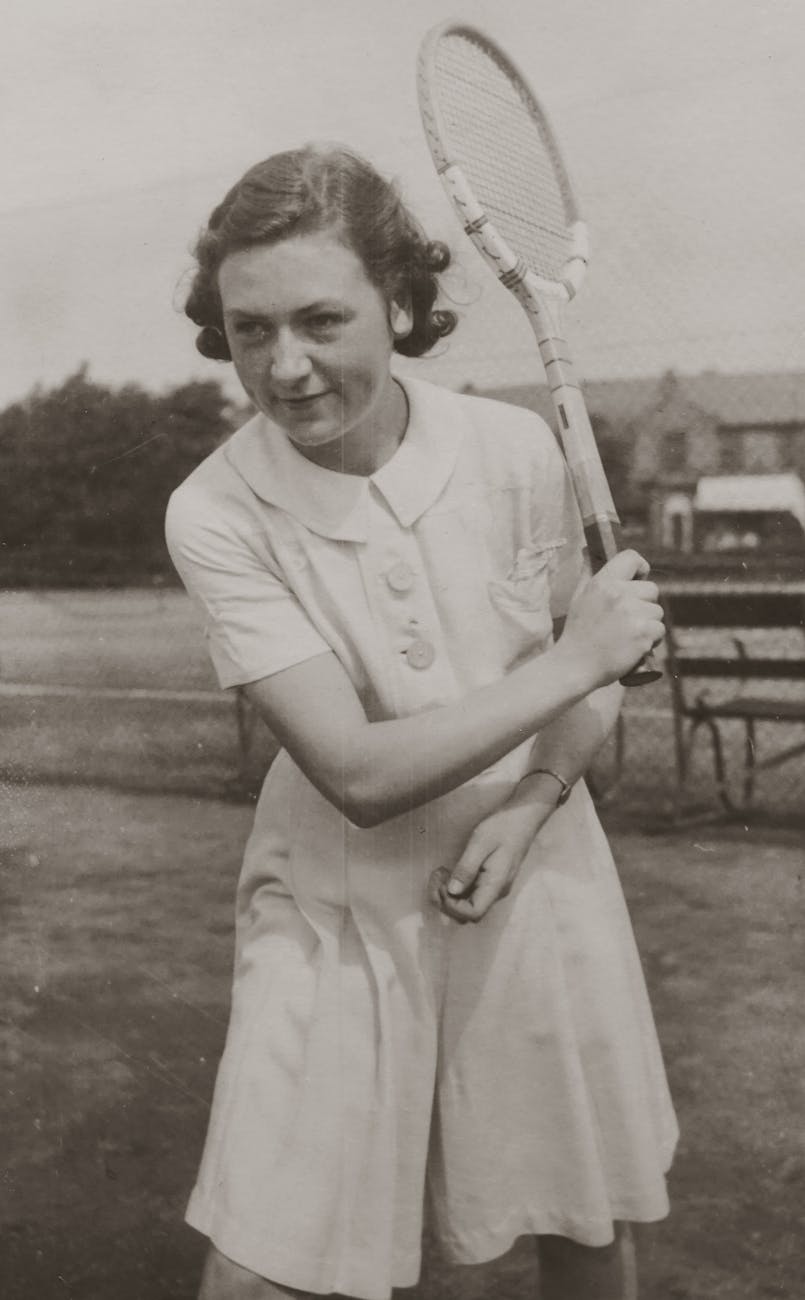 woman in white sportswear holding a tennis racket